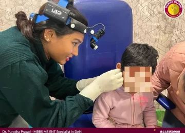 Dr. Purodha Prasad cleaning girl child ears in Delhi.