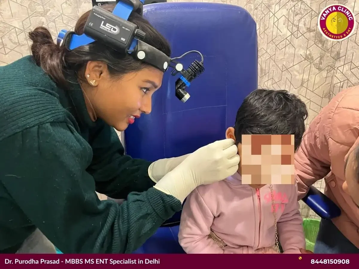 Dr. Purodha Prasad cleaning girl child ears in Delhi.