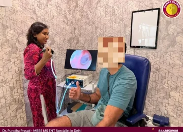 Dr. Purodha Prasad showing patient a clean ear canal on endoscope in Delhi.