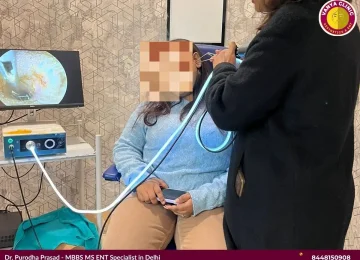 Dr. Purodha Prasad doing Ear wax removal from female patient ear in Delhi.