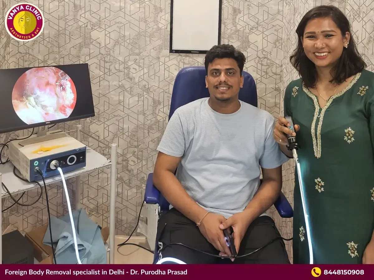 Dr. Purodha Prasad holding endoscope with happy male patient.