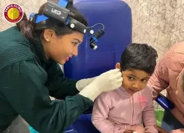 Dr. Purodha Prasad doing ear cleaning of child.