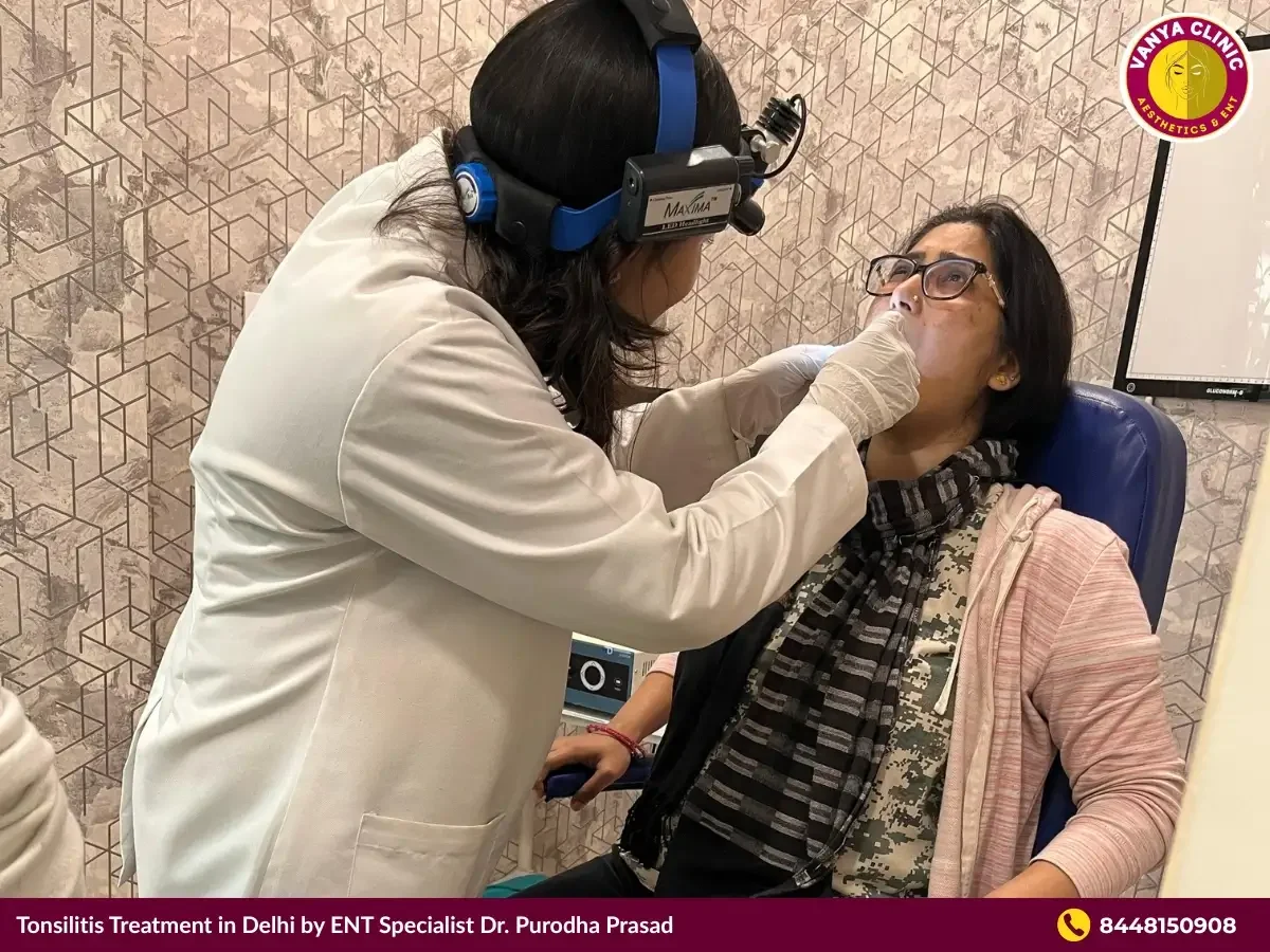 Dr. Purodha Prasad checking tonsils of patient in Delhi.